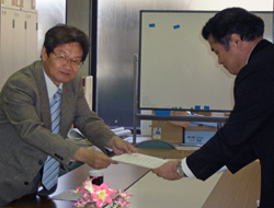 要望書を手渡す須川議長（左）と受け取る市民局九星雇用・勤労施策担当課長（右）